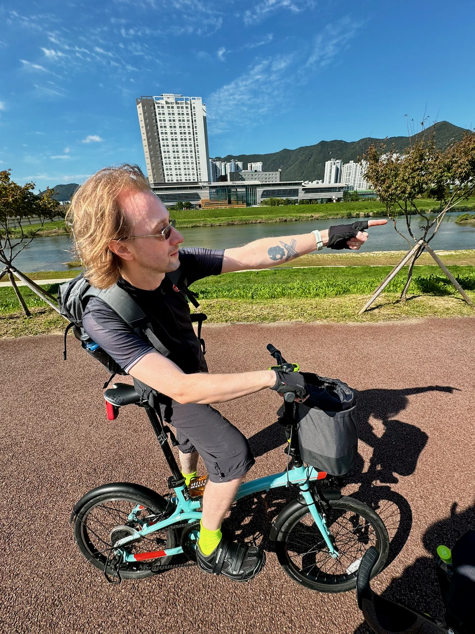 Stefan riding a bike on a riverside path in Busan